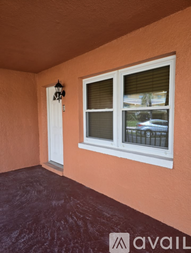 A balcony with a white door and window with blinds.