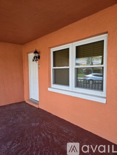A balcony with a white door and window with blinds.