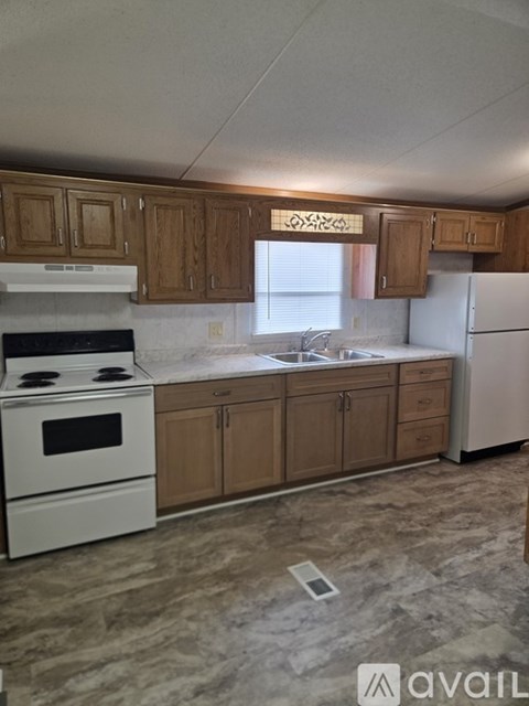 A kitchen with wooden cabinets and a white stove top oven.