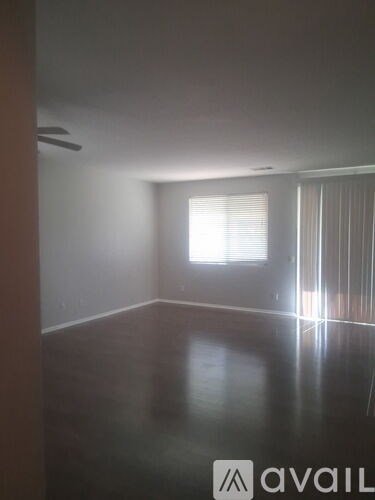 A room with a window and a wooden floor.