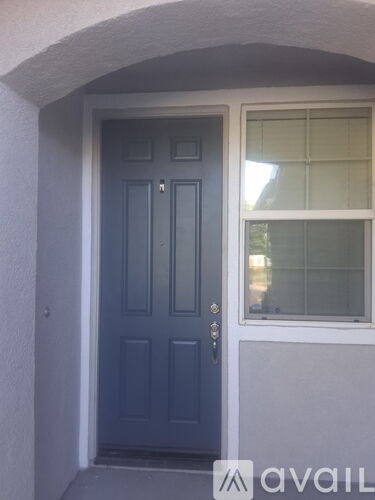 A blue door is in front of a window.