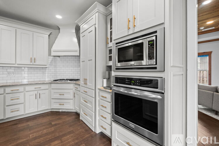 A kitchen with white cabinets and stainless steel appliances.