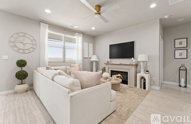 A living room with a white couch, a fireplace, and a television.
