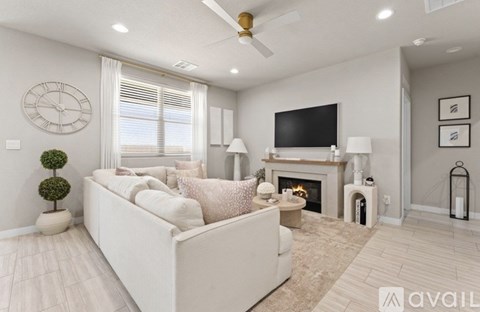 A living room with a white couch, a fireplace, and a television.