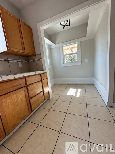 A kitchen with wooden cabinets and a tiled floor.
