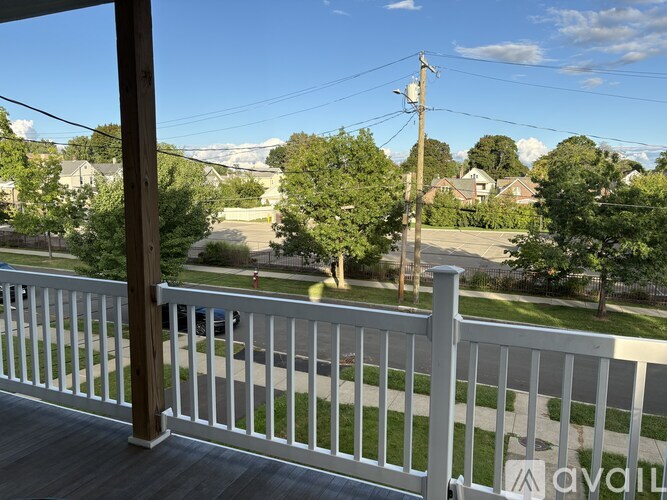 A view from a balcony overlooking a residential street.
