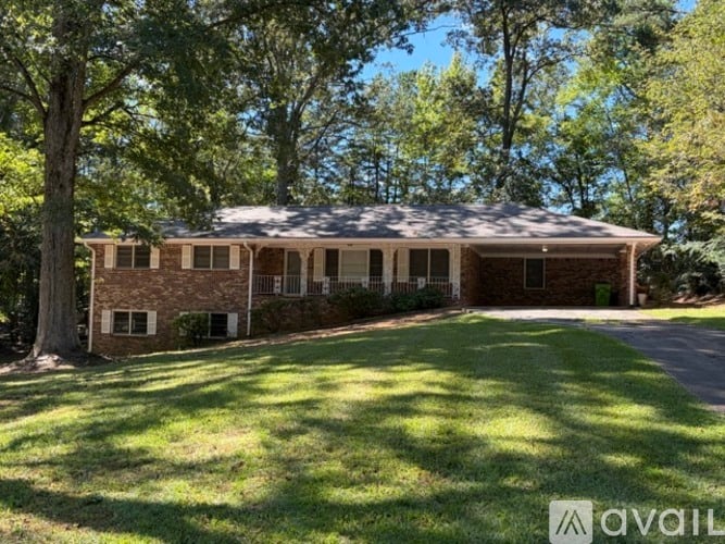A house with a large front yard and trees surrounding it.