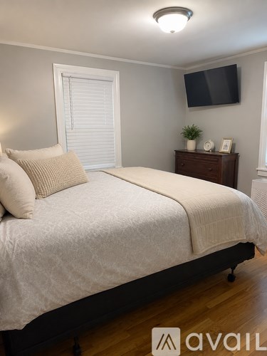 A bedroom with a bed, nightstand, and window.