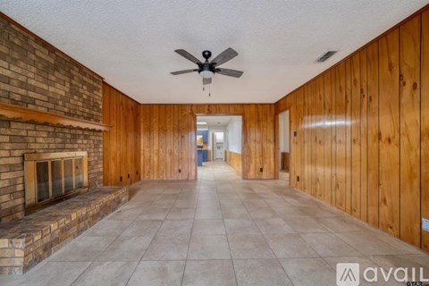 A room with wooden walls and a fireplace is available for rent.