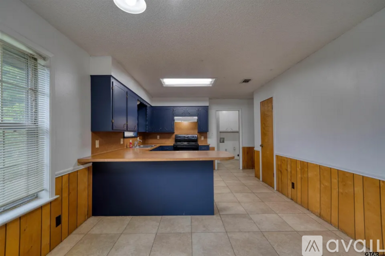 A kitchen with blue cabinets and a wooden counter.