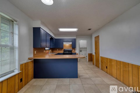 A kitchen with blue cabinets and a wooden counter.