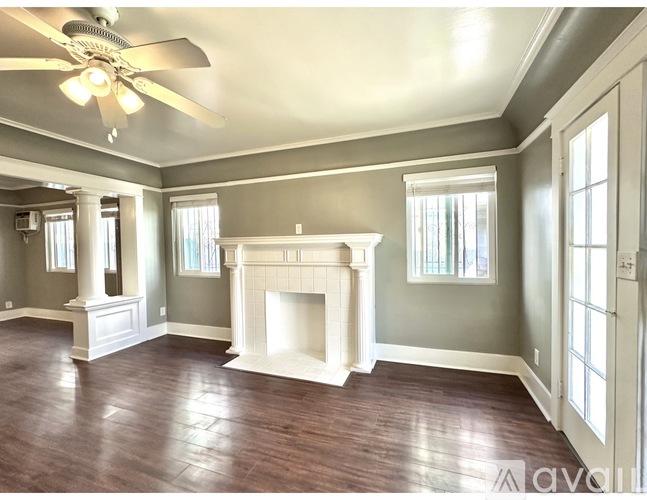 A living room with a fireplace and a ceiling fan.