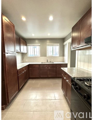 A kitchen with brown cabinets and a tiled floor.