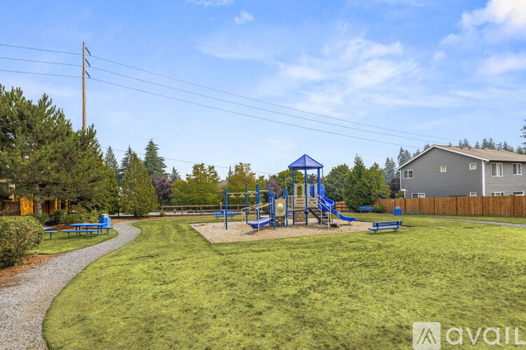 A playground with a blue swing set and a wooden fence.