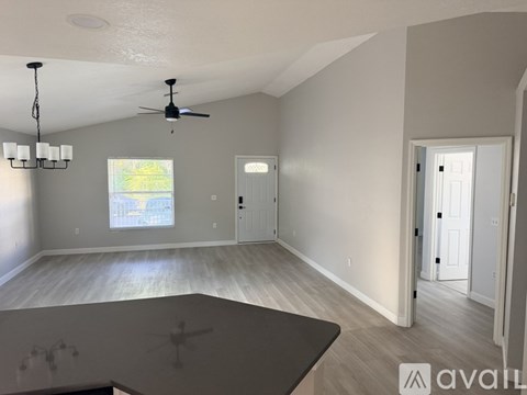 A spacious room with a ceiling fan and a large window.