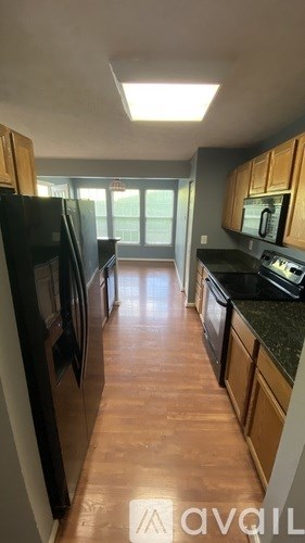 A kitchen with black appliances and wooden cabinets.