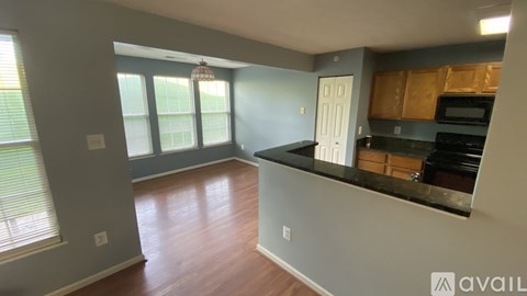 A kitchen with wooden cabinets and a black countertop.