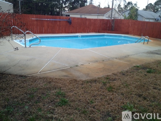 A pool surrounded by a wooden fence.