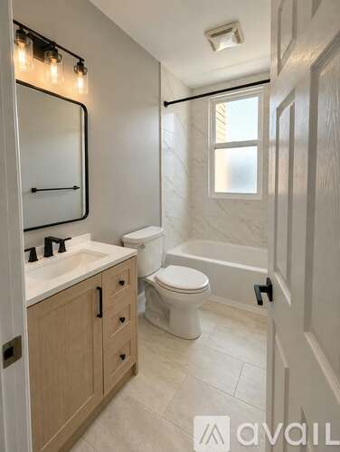A bathroom with a toilet, sink, and mirror.