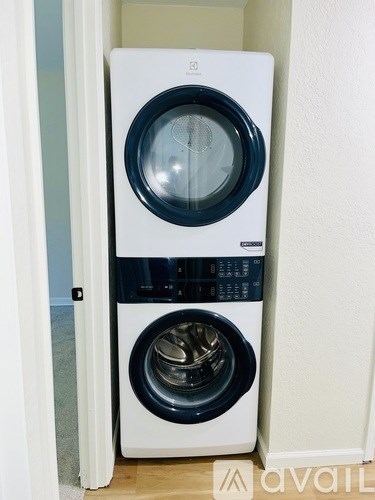 A white and black front loading washing machine in a small room.