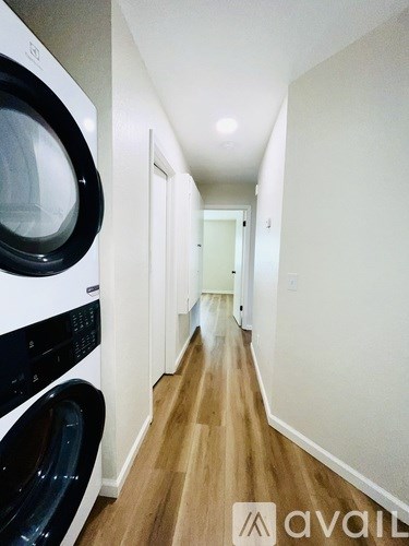 A long hallway with a washer and dryer on the left.