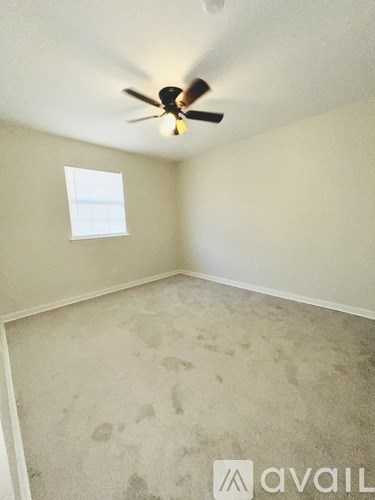 A room with a ceiling fan and a window.