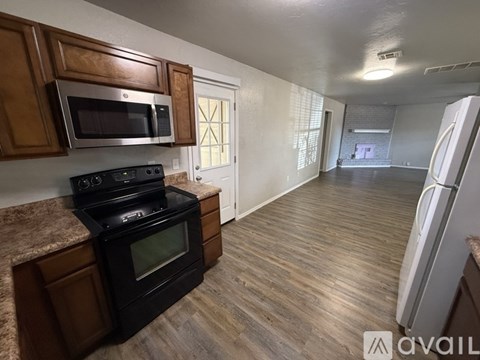 A kitchen with a black stove and microwave above a black oven.