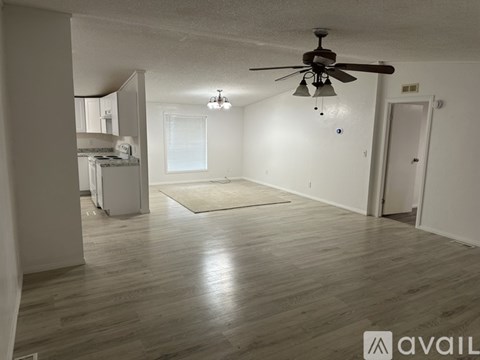 A spacious room with a ceiling fan and lighting fixtures.