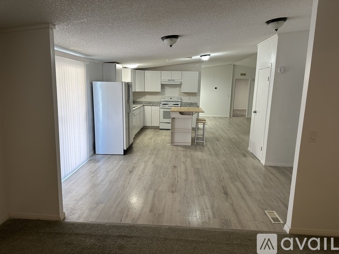 A kitchen with white appliances and cabinets is available for rent.