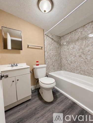 A bathroom with a toilet, sink, and bathtub.