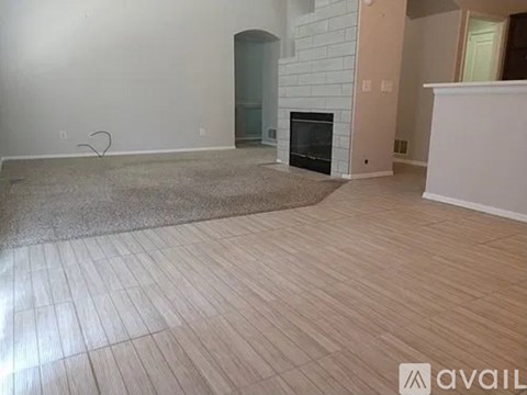 A room with a fireplace and wooden flooring.