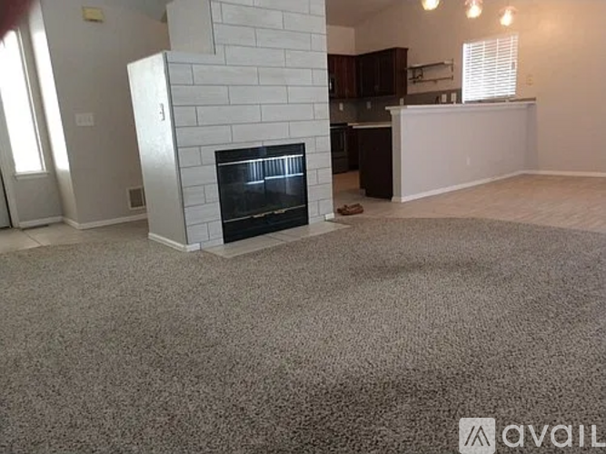 A living room with a fireplace and a carpeted floor.