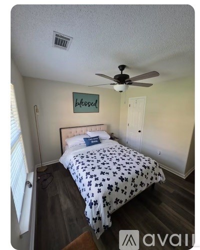 A bedroom with a bed and a ceiling fan.