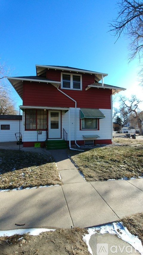 A red and white house with a green awning.
