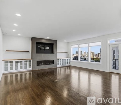 A spacious living room with a fireplace and a television.