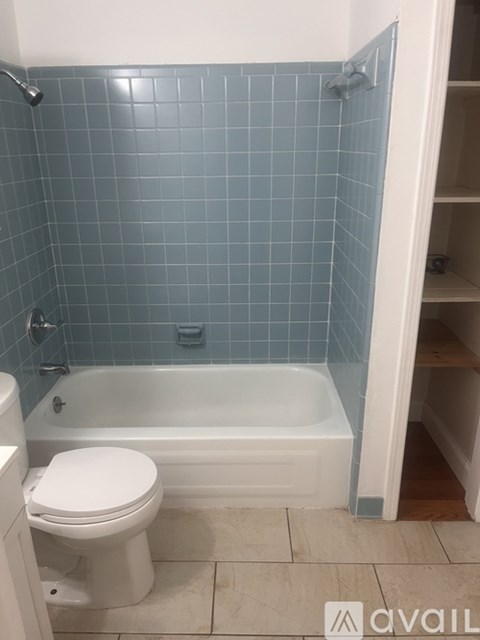 A white toilet sits next to a bathtub in a bathroom.