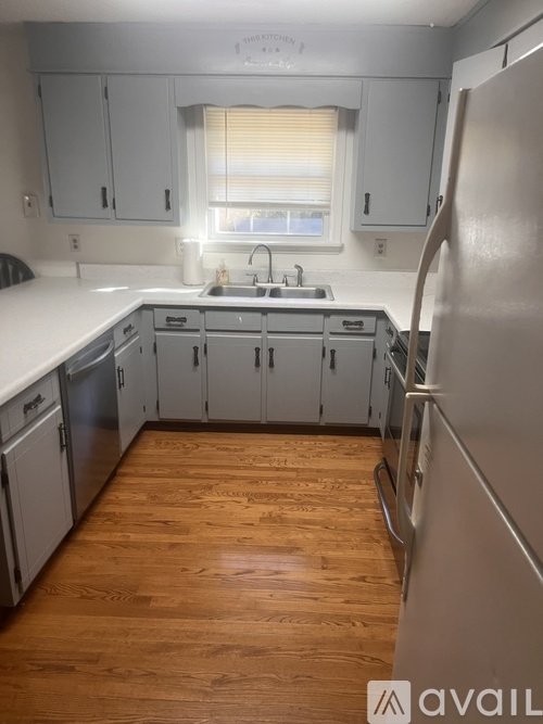 A kitchen with wooden floors and white appliances.