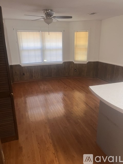 A room with wooden floors and a ceiling fan.