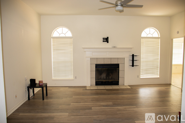 A living room with a fireplace and a ceiling fan.