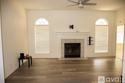 A living room with a fireplace and a ceiling fan.