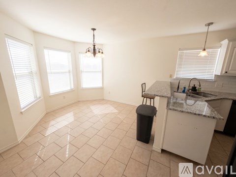 A kitchen with a counter and a trash can.