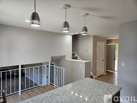 A living room with a marble table and a balcony with white railings.