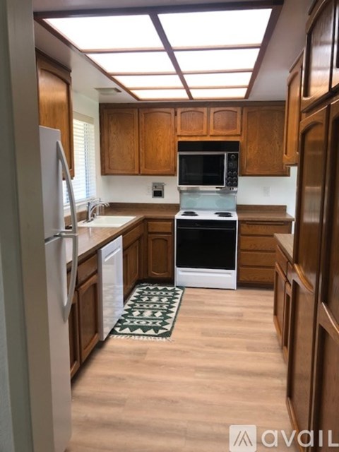 A kitchen with wooden cabinets and a white oven.