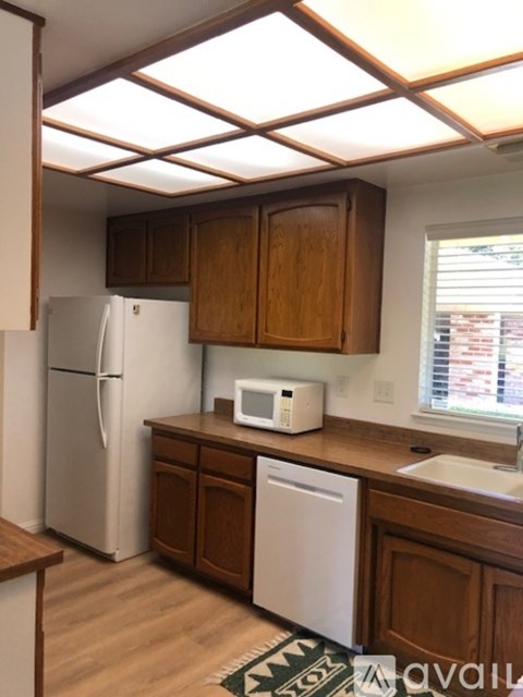 A kitchen with wooden cabinets and a white refrigerator.