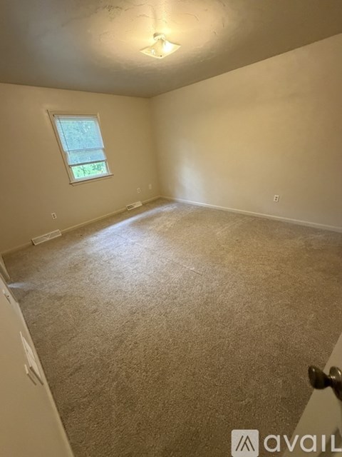 A room with a carpeted floor and a window.