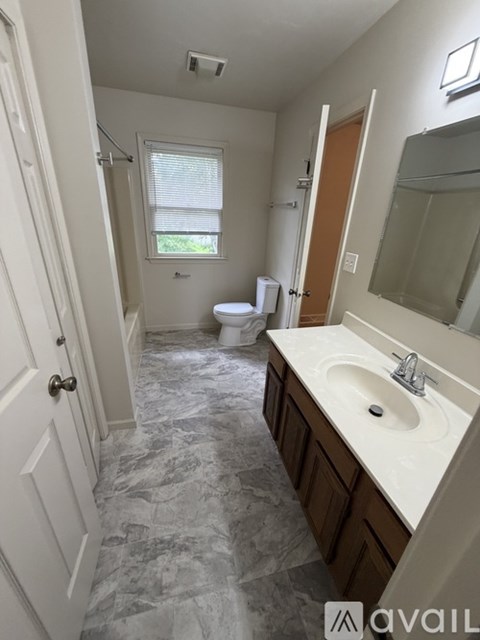 A bathroom with a marble floor and a white sink.