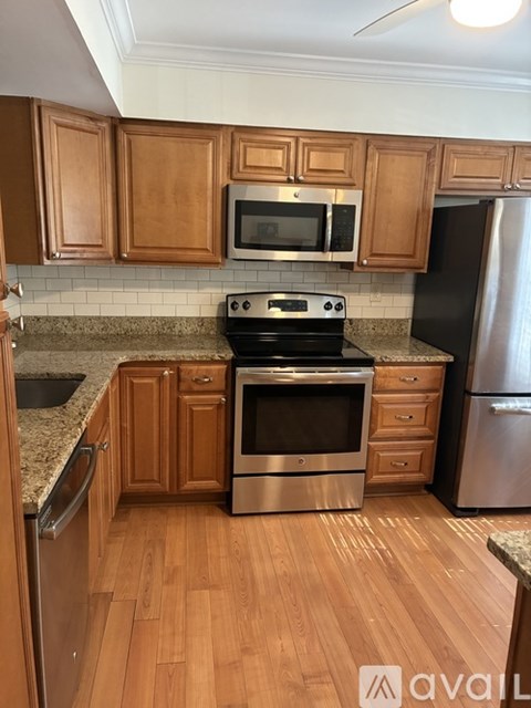 A kitchen with wooden cabinets and a black stove top oven.
