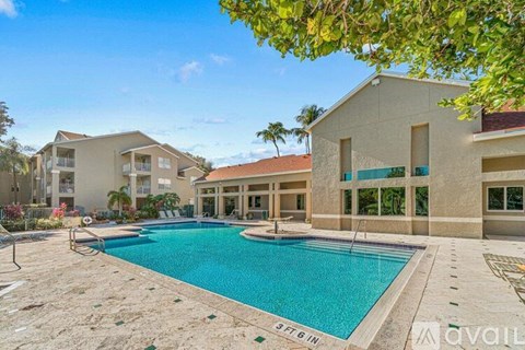 A large swimming pool in front of a building with a sign that says "available".