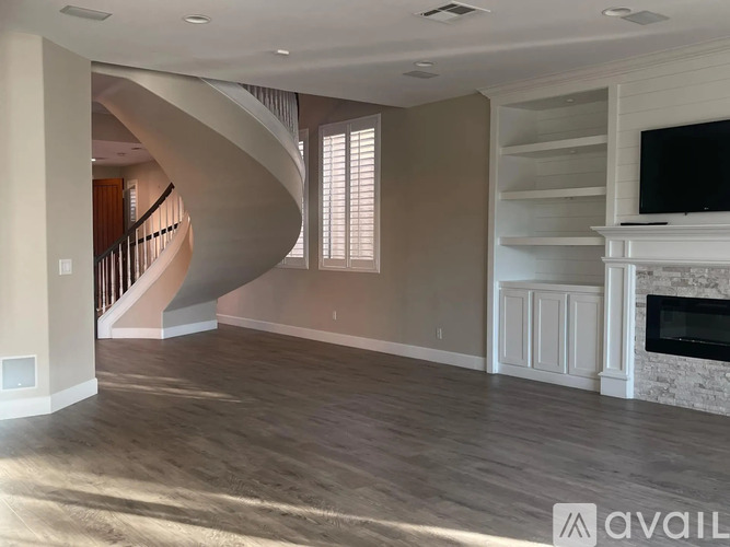 A living room with a spiral staircase and a fireplace.