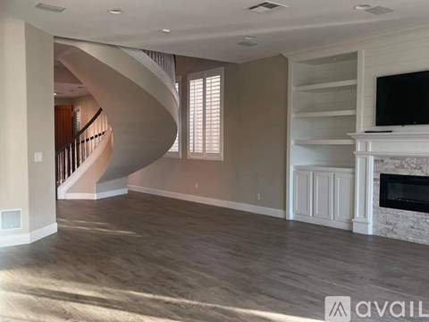 A living room with a spiral staircase and a fireplace.